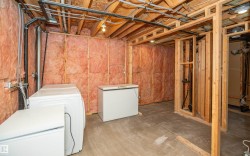 Unfinished basement featuring exposed wood framing and insulation, providing an expansive area for customization - 