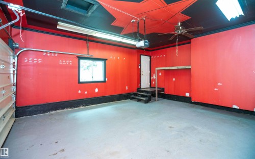 Spacious garage featuring a concrete floor, overhead fluorescent lighting, and a ceiling fan - 5116 51 Avenue, Pickardville, AB - Indoor