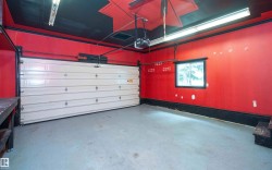 Garage space featuring a paneled overhead door, concrete flooring, and a single window - 