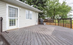 Spacious exterior deck with wood-finish flooring and a wood railing system - 