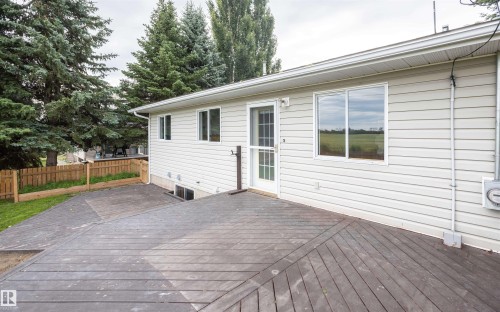 Exterior siding featuring multiple windows, a rear entry door, and an expansive composite deck - 5116 51 Avenue, Pickardville, AB - Outdoor With Deck Patio Veranda With Exterior