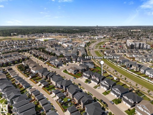 Aerial view of a residential neighborhood with detached homes, roads, and commercial properties - 6875 Evans Wynd Nw, Edmonton, AB - Outdoor With View