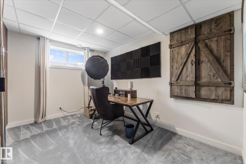 Versatile room featuring a drop ceiling with recessed lighting, light gray carpeting, and a window with white trim and curtains - 6875 Evans Wynd Nw, Edmonton, AB - Indoor Photo Showing Office