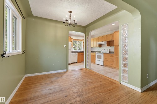 Kitchen featuring light wood cabinetry, white appliances, and tiled flooring - 7754 80 Avenue Nw, Edmonton, AB - Indoor