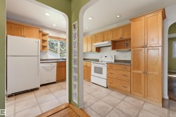Kitchen featuring wood cabinetry, white appliances, recessed lighting, tile flooring, and a window above the sink - 