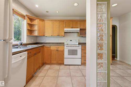 Kitchen featuring wood cabinetry, white appliances, a double basin sink, and recessed lighting - 7754 80 Avenue Nw, Edmonton, AB - Indoor Photo Showing Kitchen With Double Sink