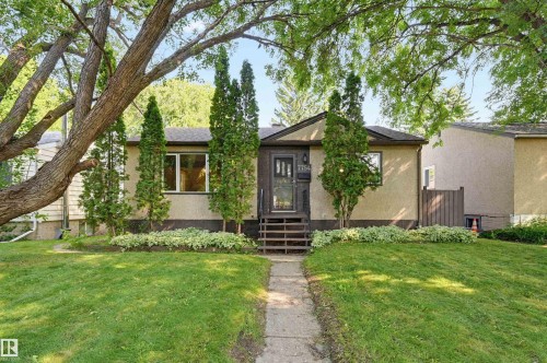 Bungalow-style residence featuring a stucco exterior and a dark-toned front door with glass inserts - 7754 80 Avenue Nw, Edmonton, AB - Outdoor