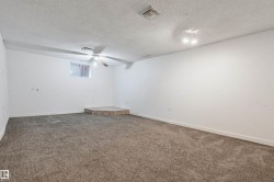 Carpeted room featuring a ceiling fan, recessed lighting, and a raised platform - 