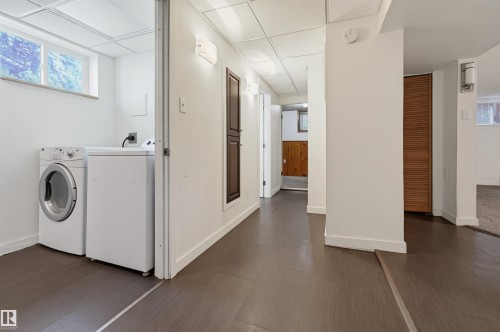 Finished basement area featuring wood-finish flooring, white walls, and recessed lighting - 7754 80 Avenue Nw, Edmonton, AB - Indoor Photo Showing Laundry Room