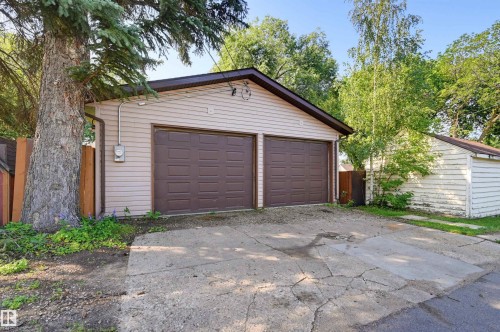 Detached two-car garage with light-colored siding and two brown overhead doors - 7754 80 Avenue Nw, Edmonton, AB - Outdoor With Exterior