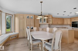 Kitchen and dining area featuring light wood-finish cabinetry, a built-in oven, and recessed lighting - 