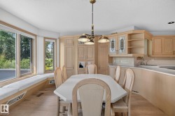 Dining area featuring a built-in window bench with cushioned seating and expansive windows - 