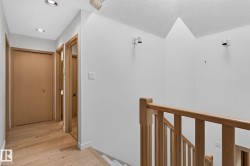 Hallway featuring recessed lighting, wood-finish flooring, and natural wood doors - 
