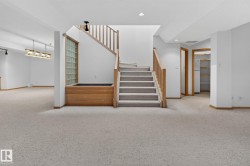 Central staircase with light wood railings and carpeted treads - 