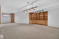 Spacious room featuring extensive built-in wooden shelving and cabinetry - 