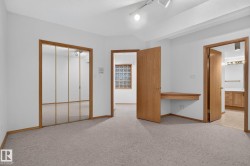 Carpeted interior space featuring white walls and light wood trim - 