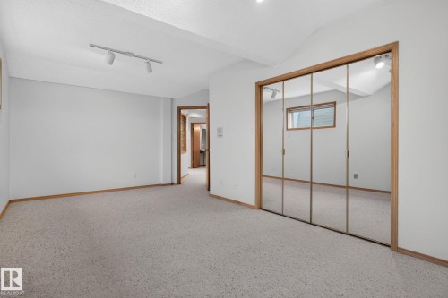 Spacious room featuring light-toned carpet flooring and white painted walls - 120 Ironwood Place Nw, Edmonton, AB - Indoor Photo Showing Other Room