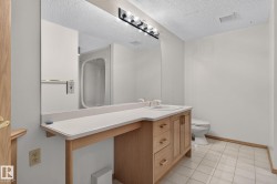 Bathroom vanity featuring a light wood cabinet with storage, white countertop, and integrated sink - 