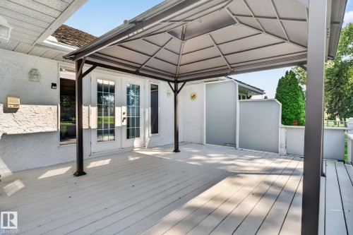 Spacious outdoor deck featuring a fixed gazebo structure, white painted plank flooring, and double French doors with sidelights - 120 Ironwood Place Nw, Edmonton, AB - Outdoor With Deck Patio Veranda With Exterior