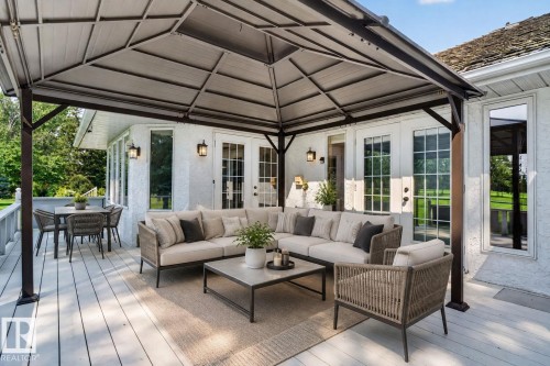 Expansive deck featuring light-toned composite decking, a metal-framed gazebo, and multiple French doors - 120 Ironwood Place Nw, Edmonton, AB - Outdoor With Deck Patio Veranda With Exterior