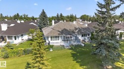 Expansive backyard featuring a large elevated deck, mature evergreen trees, and a sloped lawn - 
