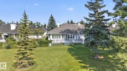 Expansive green lawn with mature evergreen trees and shrubbery - 