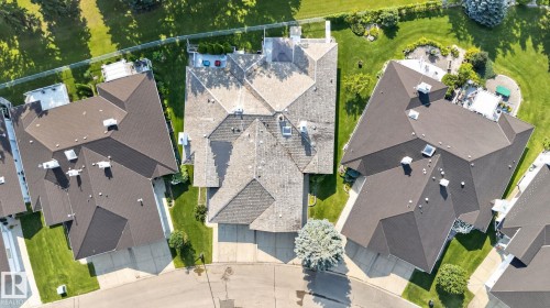 Shingled roofline over a multi-level residence with a paved driveway and landscaped grounds - 120 Ironwood Place Nw, Edmonton, AB - Outdoor With View