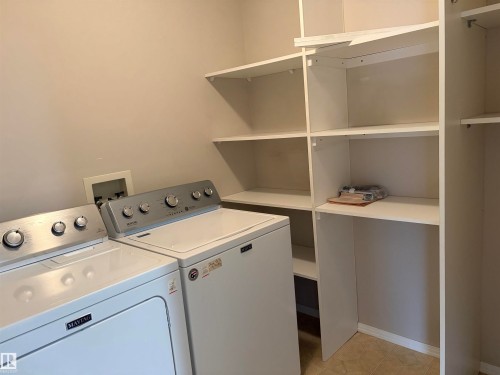 Dedicated laundry area featuring a washer and dryer setup - #209 8912 156 St Nw, Edmonton, AB - Indoor