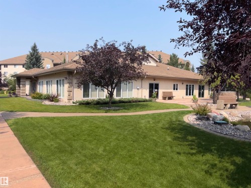 Stucco exterior structure with a low-pitch roof and multiple large windows - #209 8912 156 St Nw, Edmonton, AB - Outdoor With Facade