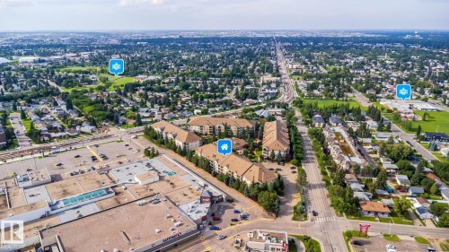 Extensive commercial property frontage, featuring multiple retail structures, and a large paved parking area - #209 8912 156 St Nw, Edmonton, AB - Outdoor With View