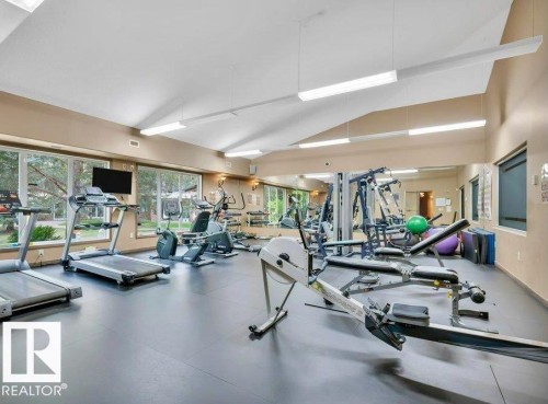 Varying ceiling heights, exposed beam, recessed lighting, expansive windows, wall-mounted mirror - #209 8912 156 St Nw, Edmonton, AB - Indoor Photo Showing Gym Room