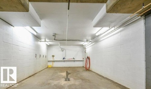 Concrete block walls with fluorescent strip lighting - #209 8912 156 St Nw, Edmonton, AB - Indoor Photo Showing Garage