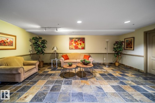 Multi-toned slate flooring, recessed ceiling lighting, track lighting, chair rail molding, and a paneled door - #209 8912 156 St Nw, Edmonton, AB - Indoor