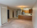 Open-concept living space featuring light-toned carpet flooring and neutral wall paint - #209 8912 156 St Nw, Edmonton, AB  - Indoor Photo Showing Kitchen 