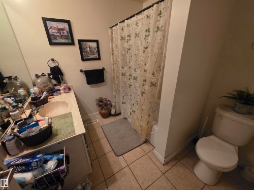 Bathroom featuring a single vanity with an integrated sink, a built-in tub with shower, and tile flooring - 38 Greenwood Drive, Spruce Grove, AB - Indoor Photo Showing Bathroom