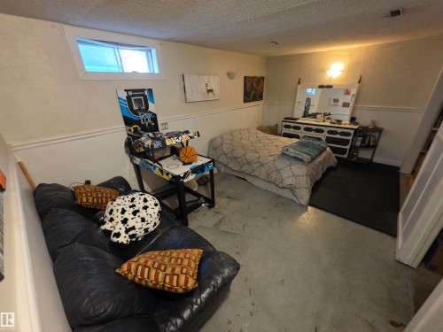 Finished basement space with concrete flooring, white walls, and a single egress window - 38 Greenwood Drive, Spruce Grove, AB - Indoor
