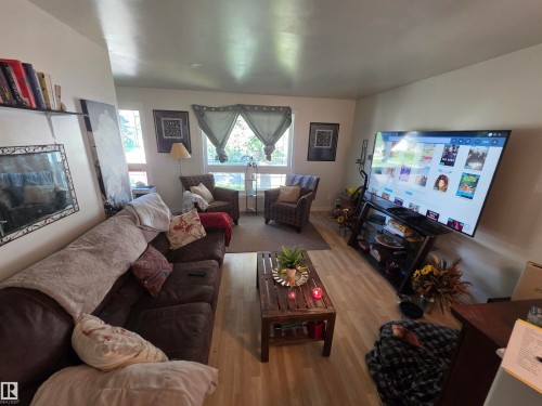 Living area featuring light wood-finish flooring, white walls, and a large window with privacy coverings - 38 Greenwood Drive, Spruce Grove, AB - Indoor Photo Showing Living Room
