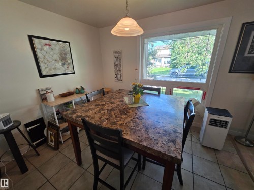 Dining area featuring a prominent window, a ceiling-mounted light fixture, and tile flooring - 38 Greenwood Drive, Spruce Grove, AB - Indoor Photo Showing Dining Room
