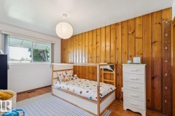 Interior space featuring a prominent wood panel accent wall and wood-finish flooring - 
