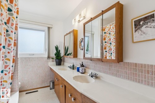 Dual vanity with integrated sinks, wood-finish cabinetry, and individual mirrored medicine cabinets - 12835 91 Street Nw, Edmonton, AB - Indoor Photo Showing Bathroom
