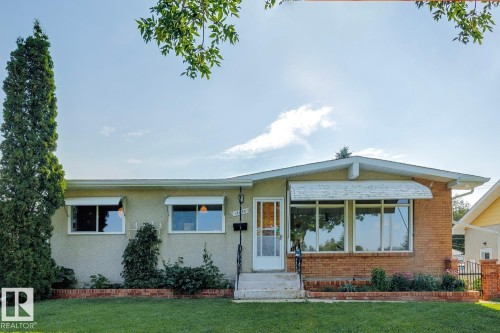 Ranch-style exterior featuring a stucco and brick facade with a wide, arched picture window - 12835 91 Street Nw, Edmonton, AB - Outdoor