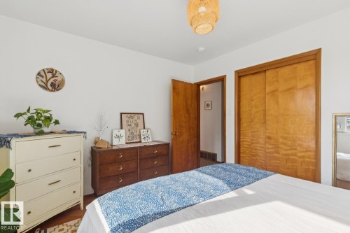 Hardwood flooring underfoot, white walls, and a natural wood door frame define this room - 12835 91 Street Nw, Edmonton, AB - Indoor Photo Showing Bedroom