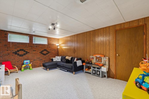Spacious room featuring light-colored carpeting and a white acoustic tile ceiling - 12835 91 Street Nw, Edmonton, AB - Indoor