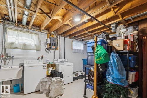 Lower level laundry area featuring an exposed wood joist ceiling, a utility sink, and a window - 12835 91 Street Nw, Edmonton, AB - Indoor Photo Showing Laundry Room