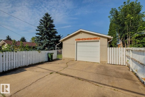 Detached garage featuring a white overhead door and brick detailing - 12835 91 Street Nw, Edmonton, AB - Outdoor