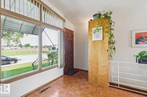 Entryway featuring large picture windows with an upper transom, wood-finish flooring, and a solid wood front door - 12835 91 Street Nw, Edmonton, AB - Indoor Photo Showing Other Room