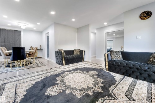 Open-concept living space featuring light wood-finish flooring, recessed lighting, and a dining area with a modern chandelier - 7419 33 Avenue Nw, Edmonton, AB - Indoor Photo Showing Living Room