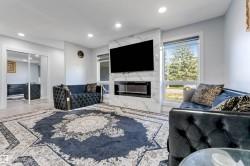 Living area featuring a floor-to-ceiling fireplace with a marble-finish surround and an integrated electric firebox - 