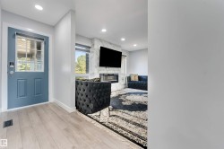 Entryway with light wood-finish flooring and a blue paneled door with glass inserts - 
