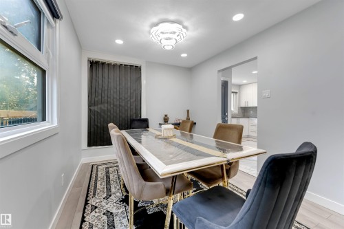 Dining area featuring recessed lighting, a modern ceiling fixture, wood-finish flooring, and white baseboards - 7419 33 Avenue Nw, Edmonton, AB - Indoor Photo Showing Dining Room